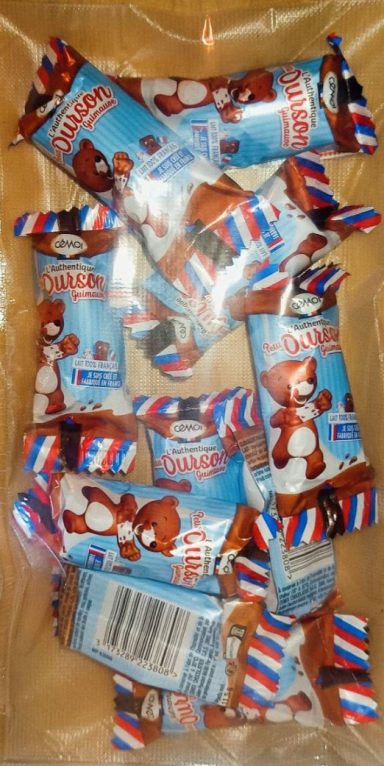 Barres de chocolat emballées, avec un motif rouge, blanc et bleu, disposées dans un plat.